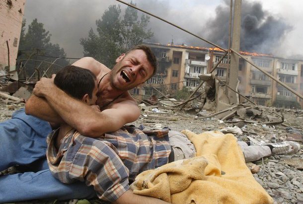 A Georgian man cries near the body of his relative after a bombardment in Gori, 80 km (50 miles) from Tbilisi, August 9, 2008. A Russian warplane dropped a bomb on an apartment block in Gori on Saturday, killing at least 5 people, a Reuters reporter said. The bomb hit the five-story building close to Georgia's embattled breakaway province of South Ossetia when Russian warplanes carried out a raid against military targets around the town. REUTERS/Gleb Garanich (GEORGIA)