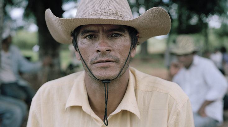 A pesant at La Terza Cué community remains jobless as the fields the community once owned are now part of a large soy plantation. They are on an ongoing conflict over the ownership of the land with the plantation company, which they accuse of steadily grabbing their lands in connivence from corrupted authorities. They also face pressure from a Rural Police group they accuse of acting on behalf of the company, as well as threats and economic pressure to leave the area. Since 2003 there had been 11 unsolved murders in the community, all by hit mans. Land grabbing and concentration of land sometimes in foreign hands is reported by national and international organizations to be one of Paraguay's major problems.